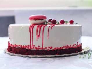 Tasty white homemade cake decorated by red berries and macaron - 190352380