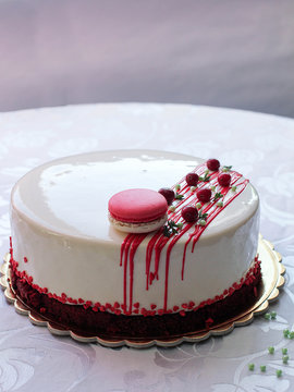 Tasty white homemade cake decorated by red berries and macaron