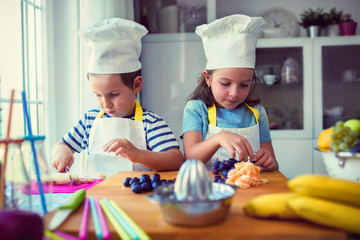 Baby chefs in the kitchen - preparing a healthy fruit snack