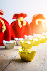 Chinese New Year Red fabric bag, ang pow with Chinese money of luck and Shoe-shaped gold ingot