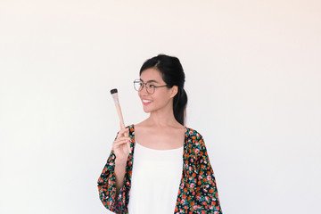 Fashion Portrait of Young cute asian woman wearing floral robe and holding paint brush