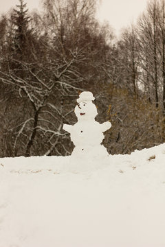 Snowman out of the snow, melting snow, spring background.