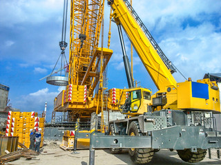 Installation of technological equipment on the construction site, using a crawler and a wheeled crane