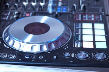 professional music equipment for playing and control music in nightclub with hands DJ . Dj mixes the track in the nightclub at party . Headphones in foreground and DJ hands in motion