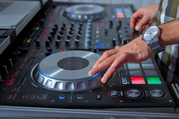 Fototapeta na wymiar professional music equipment for playing and control music in nightclub with hands DJ . Dj mixes the track in the nightclub at party . Headphones in foreground and DJ hands in motion