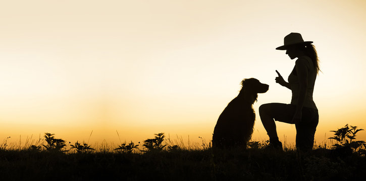 Web banner of a dog and his female trainer - silhouette image with blank, copy space