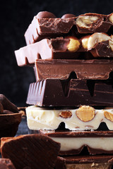 Chocolate bars on dark background with chocolate tower