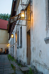 Fototapeta premium Beautiful old Iron lantern on the wall Lviv near the old vintage door, Ukraine. Characteristic phenomenon medieval architecture Central European