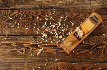 old planer and shavings on dark wooden table