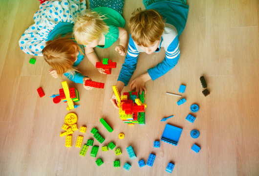kids play building with plastic blocks
