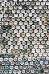 Bottle recycling: plastic bottles which have been set in concrete to form a bottle wall