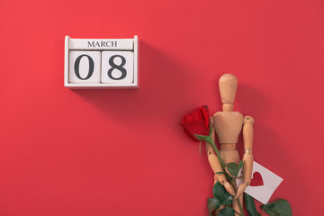 Wooden man figure with red flowers. Concept for valentine's day.