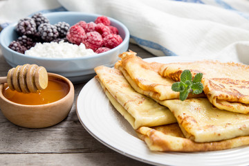 fresh pancakes with fragrant maple syrup and honey. Russian holiday pancake week. crepes with honey or syrup