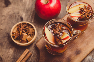 Fototapeta premium hot spicy beverage. Hot drink (apple tea, punch) with cinnamon stick and star anise. Seasonal mulled drink