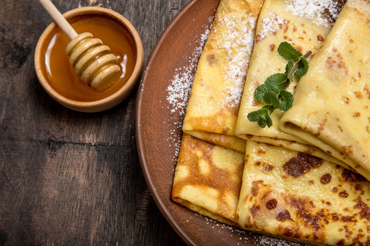 fresh pancakes with fragrant maple syrup and honey. Russian holiday pancake week. crepes with honey or syrup