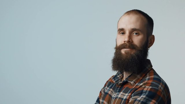 Closeup of confident bearded man standing looking at camera, portrait with copy space