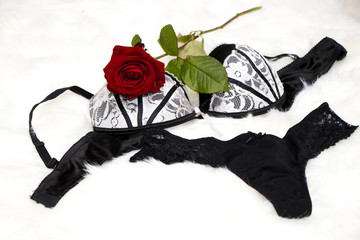 sexy black lingerie with a red rose on a white fur - valentines day - surprise verführung