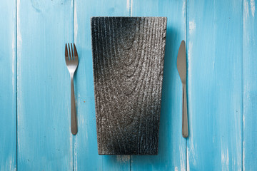 Japanese Plate with fork and knife on blue wooden background