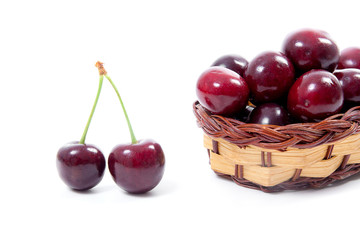 Yellow wooden basket with red sweet cherry isolated on a white background..