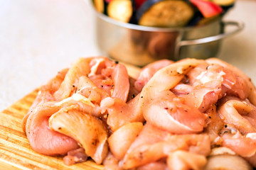 Raw spiced chicken fillet and fresh vegetables