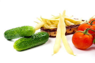 Fresh young pods of beans with beans, bunch of the fresh red tomatoes and several green cucumber with water drops on white background..