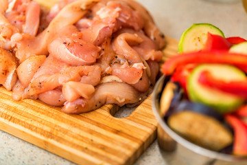 Raw spiced chicken fillet and fresh vegetables