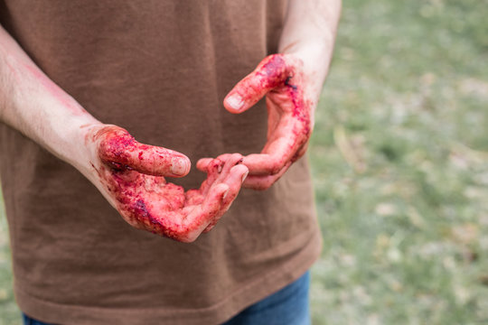close up photo of murderer's hands smeared with blood outdoors