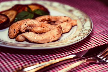 Pieces of roasted chicken and vegetables on plate