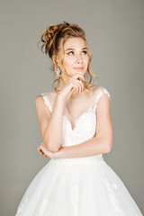 thinking bridal looking away on grey background.