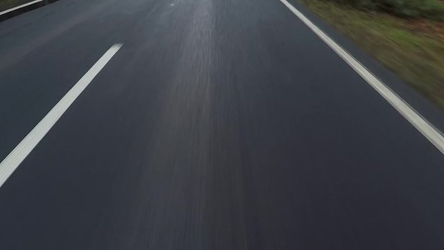car driving on a asphalt country road - POV - View of the road in the front of the car