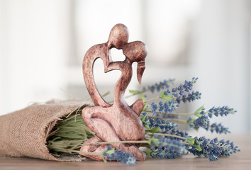 figurine in the form of two men kissing a man and a woman against a background of flowers