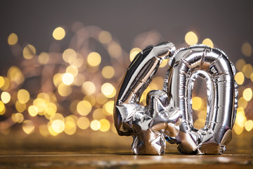 Silver number 40 celebration foil balloon against blurred light background