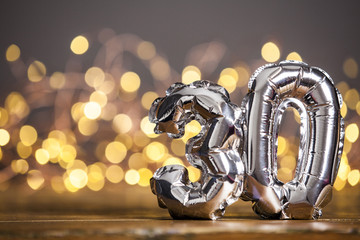 Silver number 30 celebration foil balloon against blurred light background