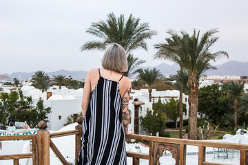 Fototapeta na wymiar back view of beautiful girl in dress standing at resort in Egypt