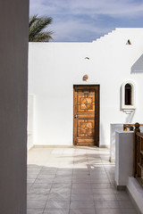 Fototapeta na wymiar wooden door in white building at resort in Egypt