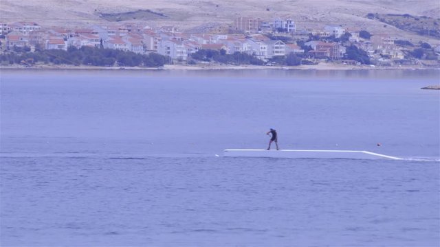 Person pulled by rope on wakeboard over stunts 4K