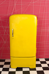 yellow old vintage retro refrigerator on a pink background
