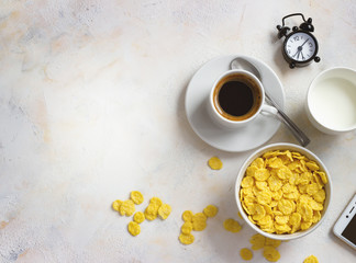 Corn flakes, coffee, alarm clock on a light background, breakfast