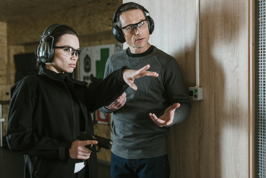 female instructor showing where shoot to client in shooting range