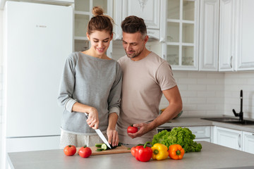 Portrait of a smiling loving couple cooking salad