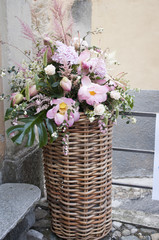 Fototapeta na wymiar large wicker vase with pink and purple flowers