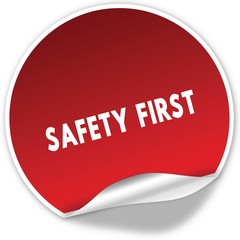 SAFETY FIRST text on realistic red sticker on white background.