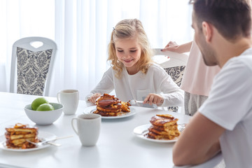 Obraz na płótnie Canvas daughter having breakfast with her parents