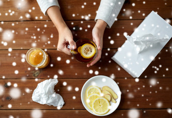 ill woman drinking tea with lemon and ginger