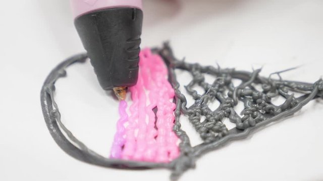 Kid hands holding yellow 3d printing pen. Top view