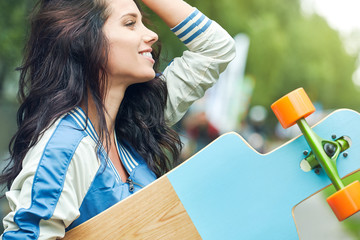 Sporty and modern woman holding longboard