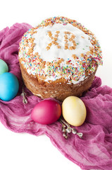 Scattered painted easter chicken eggs, traditional orthodox christian easter food kulich with raisins and branches of willow