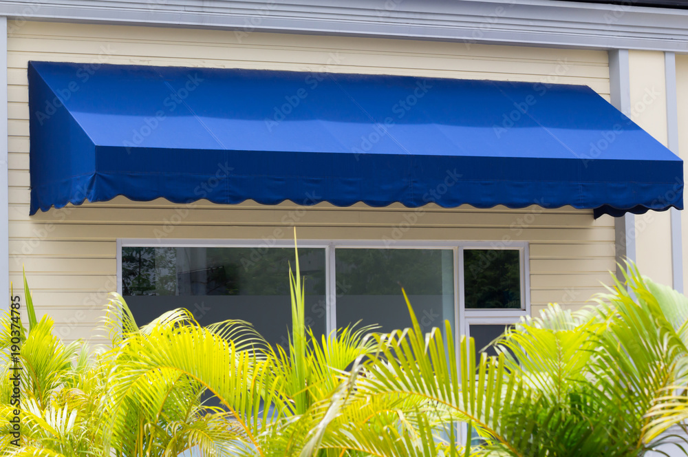 Poster blue awning over white aluminium frame window of shop