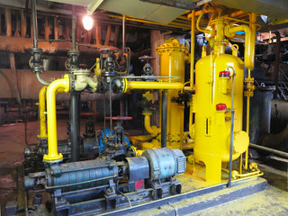 Oil pump, yellow pipes, tubes, machinery at power plant