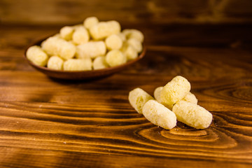 Ceramic plate with corn sticks on wooden table